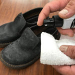 革靴への革王クリーナーによる拭き取り実施前に、革王クリーナーを布にスプレーする様子